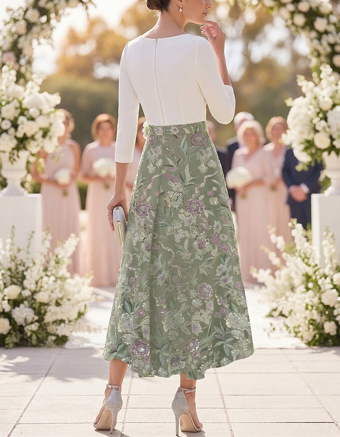 Witte en saliegroene midi-jurk met geborduurde bloemen
