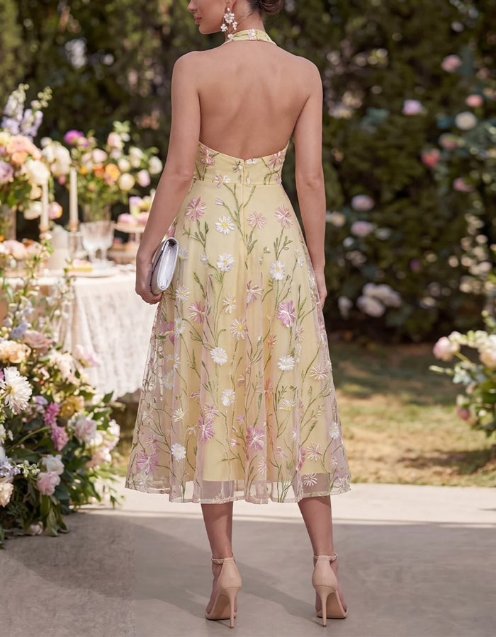 Vestido midi amarillo con cuello halter y malla bordada con flores