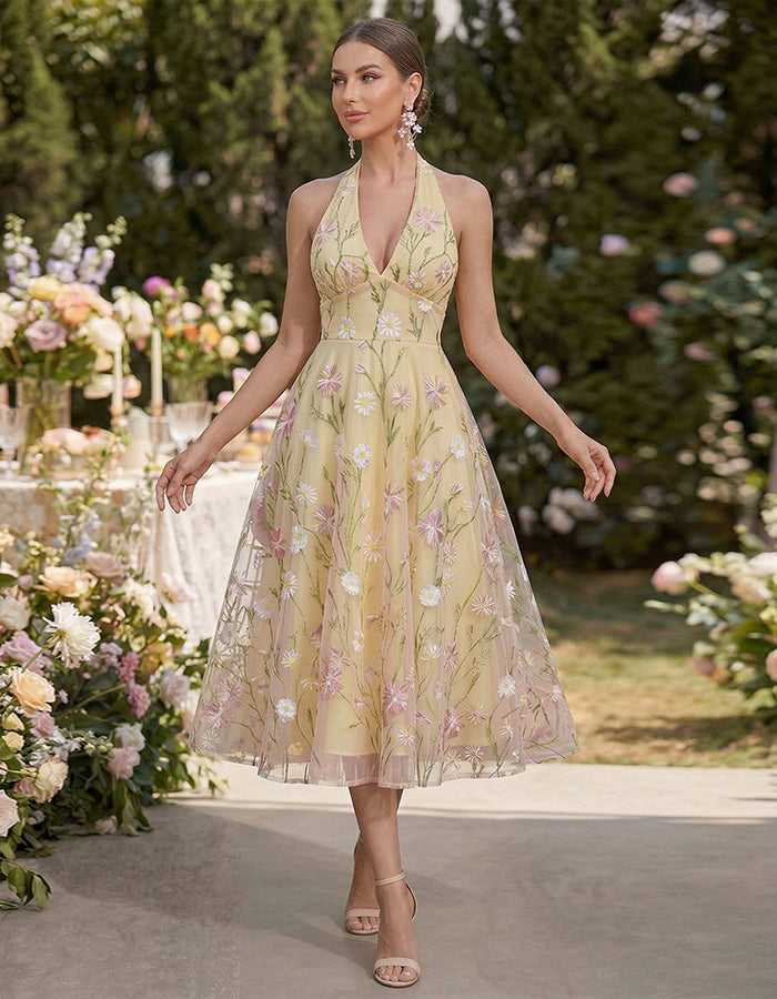 Vestido midi amarillo con cuello halter y malla bordada con flores