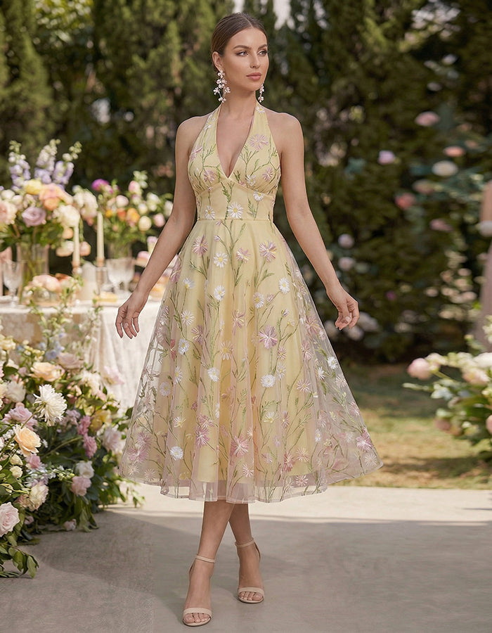 Vestido midi amarillo con cuello halter y malla bordada con flores