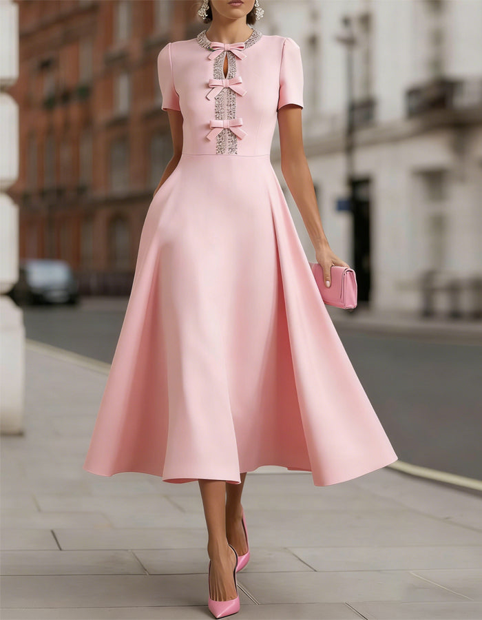 Abito midi in raso rosa con fiocco di strass che stringe la vita