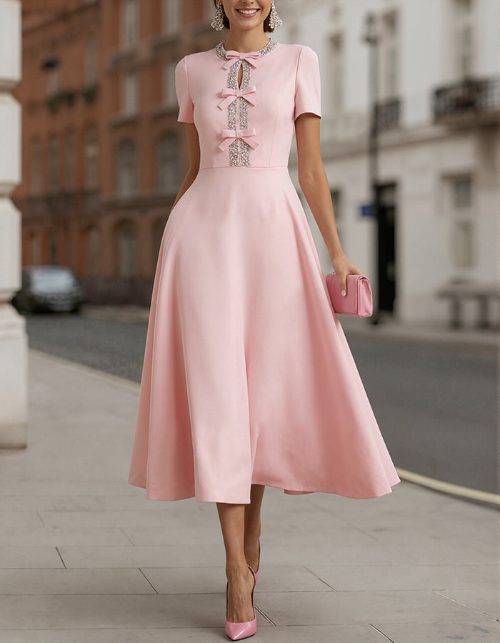 Roze satijnen midi-jurk met strass strik en tailleaccent