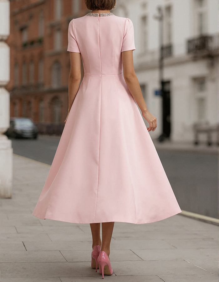 Roze satijnen midi-jurk met strass strik en tailleaccent
