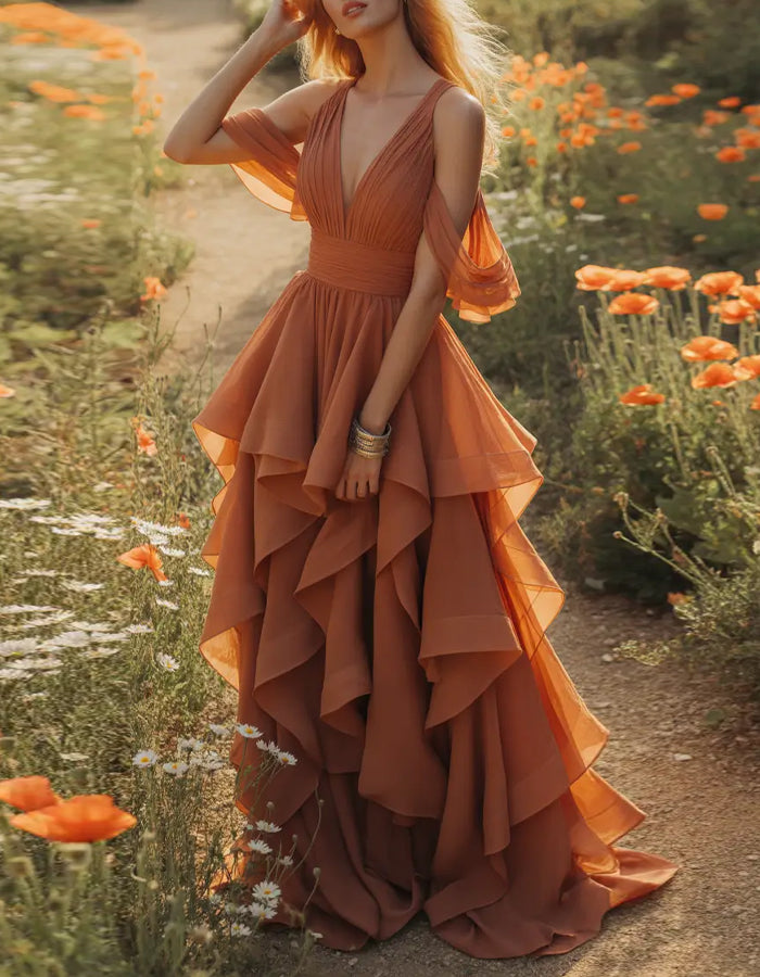 Vestido maxi terracota con escote profundo en V, hombros descubiertos, mangas con volantes y múltiples capas de gasa con volantes