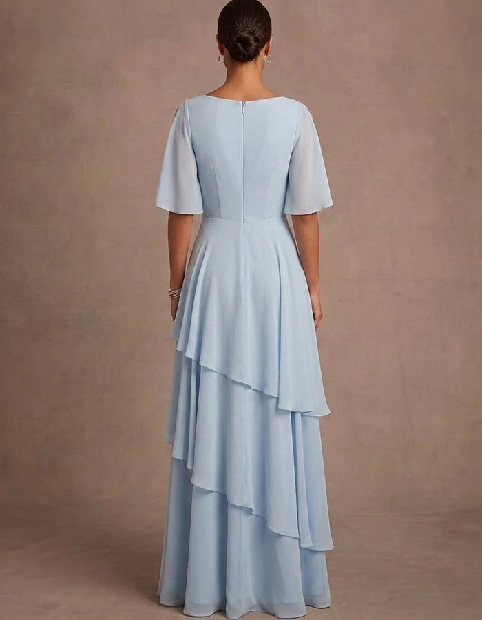 Abito lungo in chiffon azzurro con scollo profondo a V, spalle scoperte, maniche a volant e volant