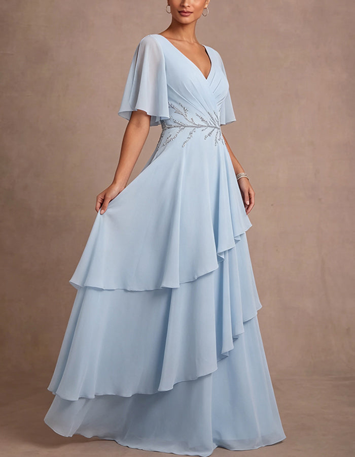 Abito lungo in chiffon azzurro con scollo profondo a V, spalle scoperte, maniche a volant e volant
