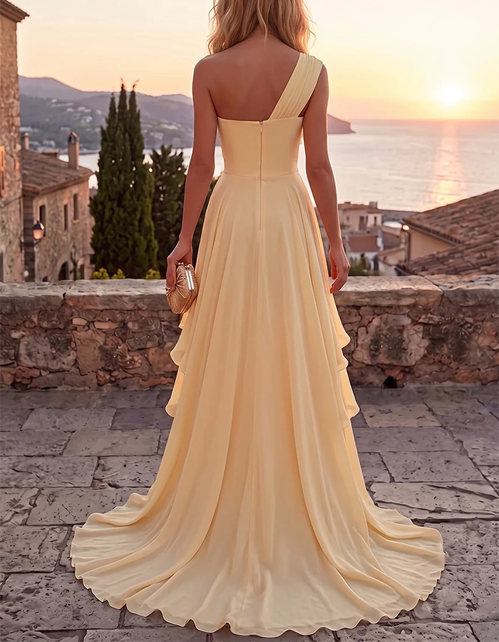 Abito maxi giallo a trapezio in chiffon a balze, con drappeggio monospalla e applicazione floreale 3D