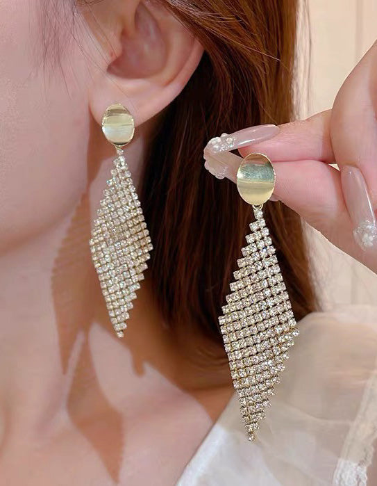 Brincos pendentes dourados com losangos totalmente adornados com strass para festas formais