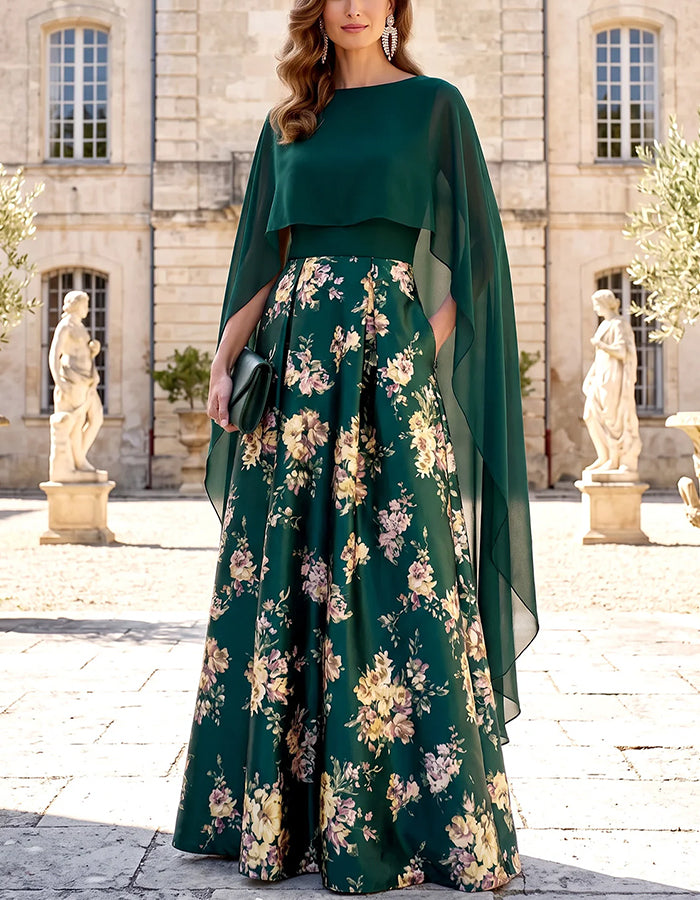 Abito lungo svasato in raso verde con mantella in chiffon, scollo a barca e stampa floreale