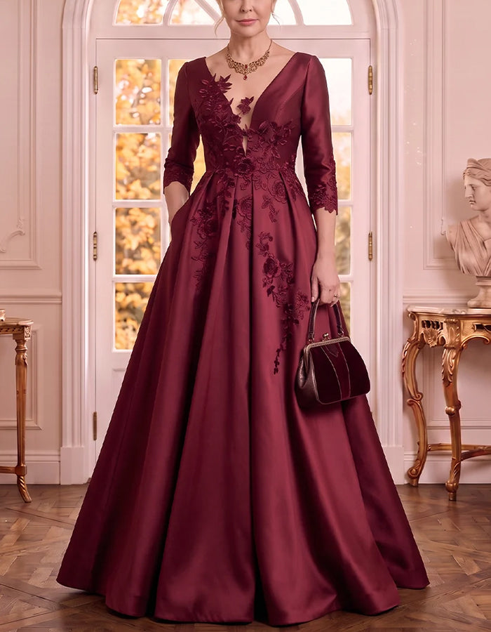 Vestido comprido de cetim com decote em V profundo, mangas 3/4, aplicações florais de renda e corte em linha A