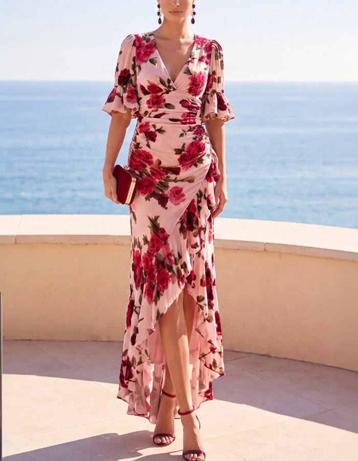 Vestido midi rosa em chiffon floral, com decote em V profundo, mangas com folhos e bainha assimétrica dianteira curta e traseira comprida