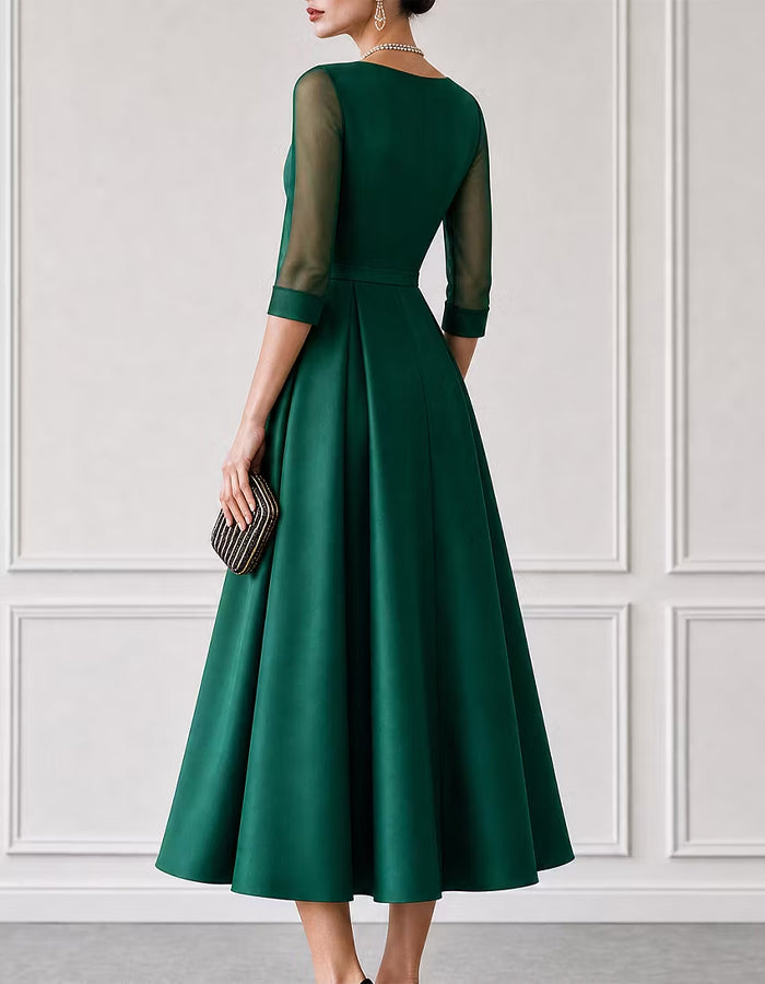 Vestido midi verde de satén con escote barco y mangas de malla de tres cuartos