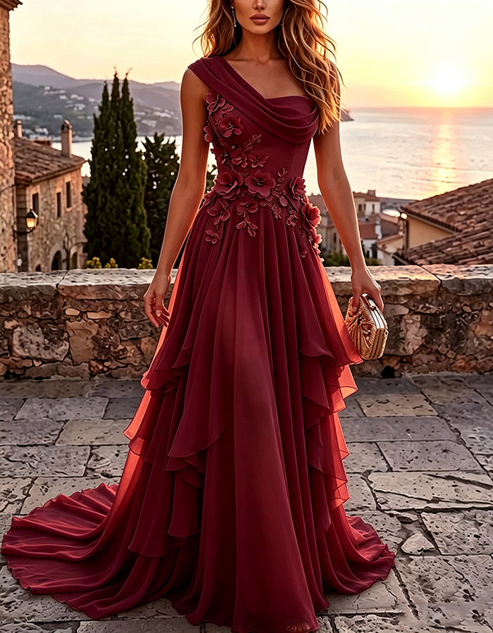 Abito maxi giallo a trapezio in chiffon a balze, con drappeggio monospalla e applicazione floreale 3D