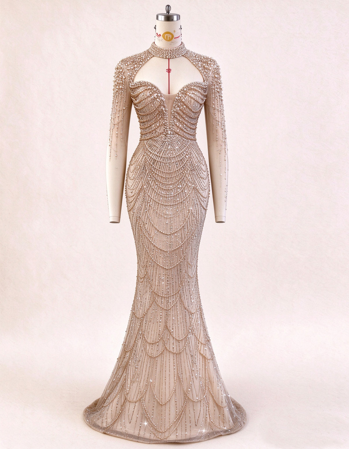Rochie de seară nude cu mâneci lungi, decupaje și lanțuri de perle