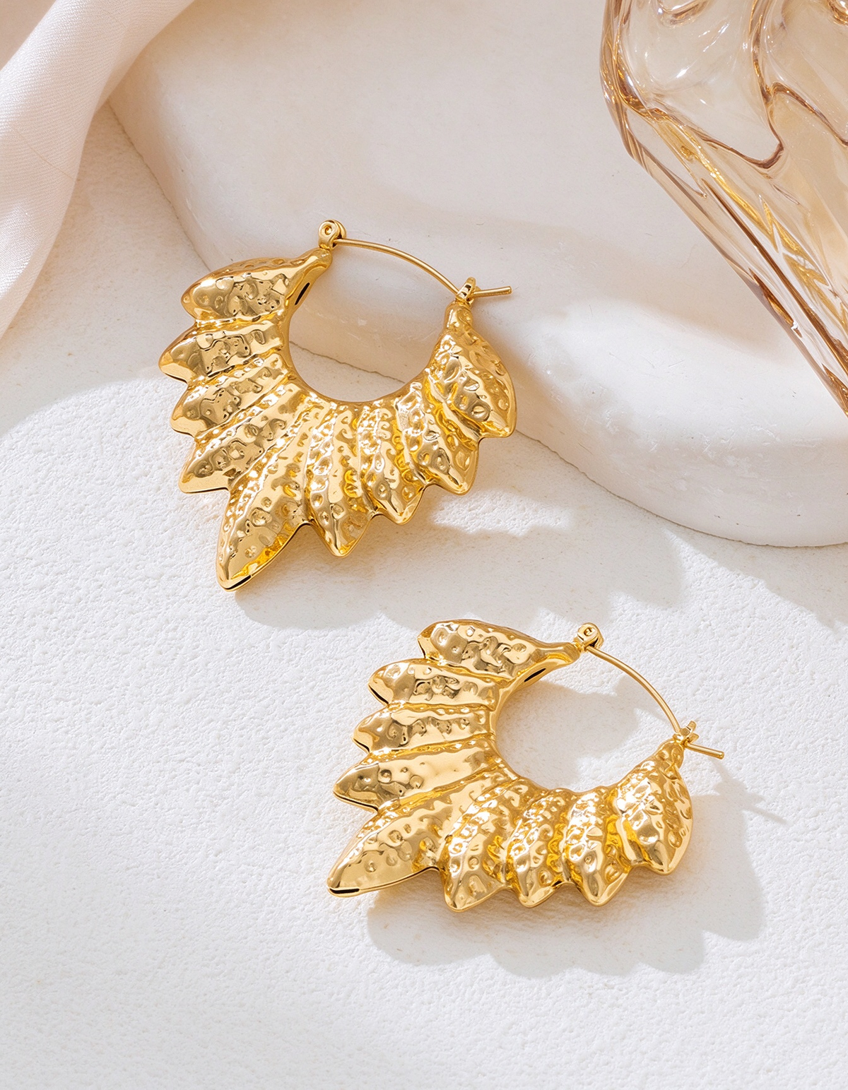 Pendientes de aro dorados con textura martillada en forma de ala