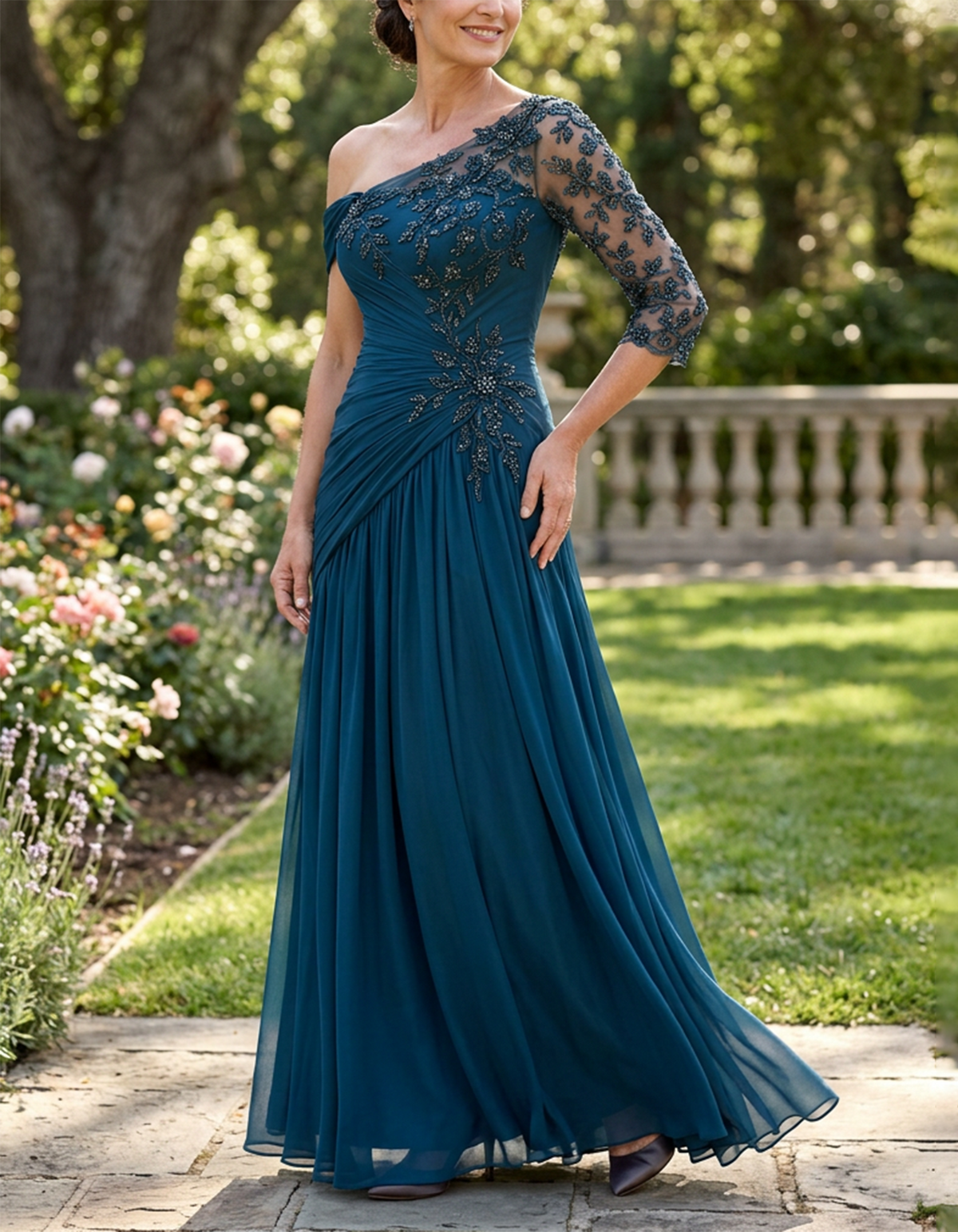 Vestido largo de gasa color verde azulado con un hombro descubierto, efecto ilusión y mangas tres cuartos