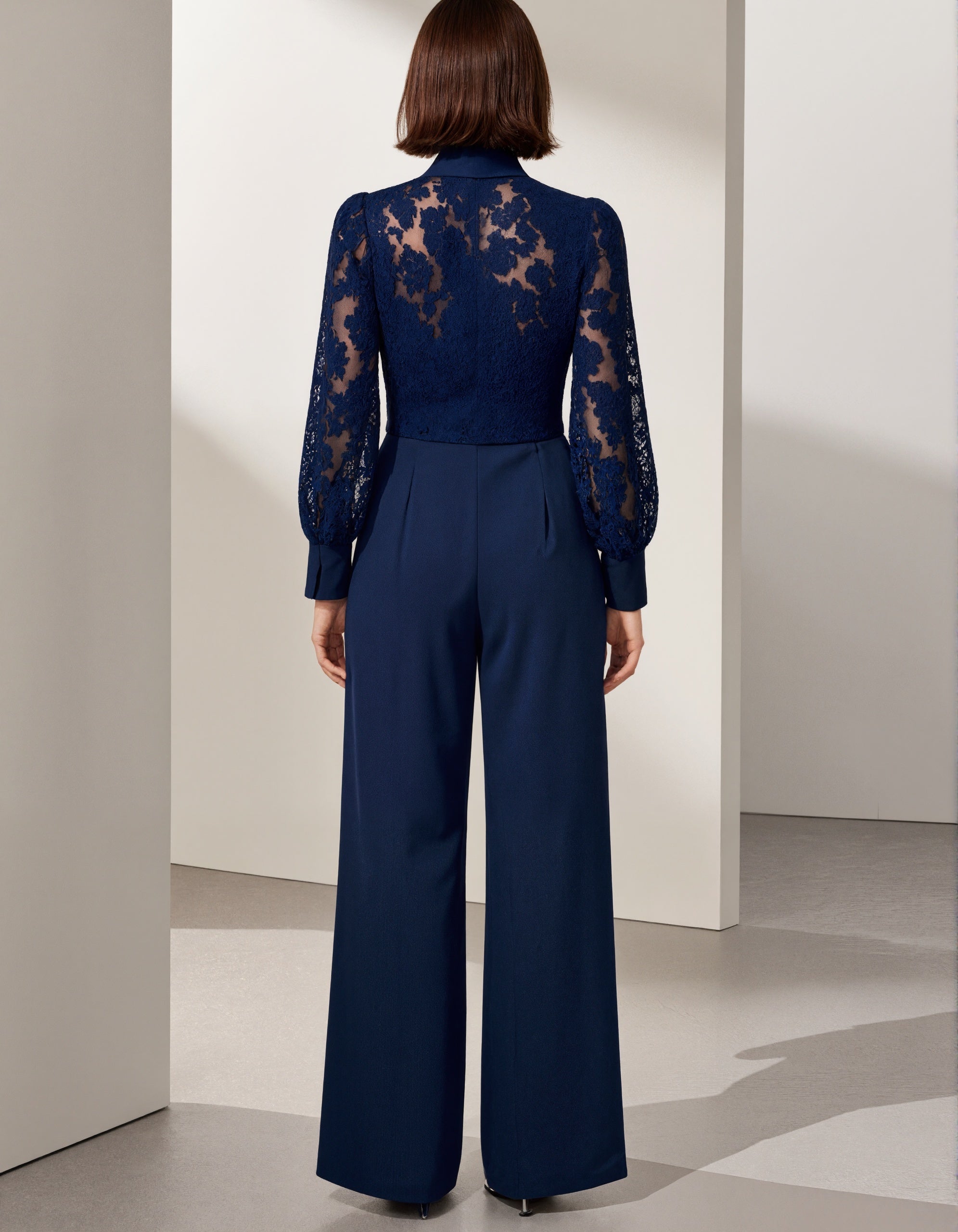 Tuta blu in pizzo con fiocco e maniche lunghe