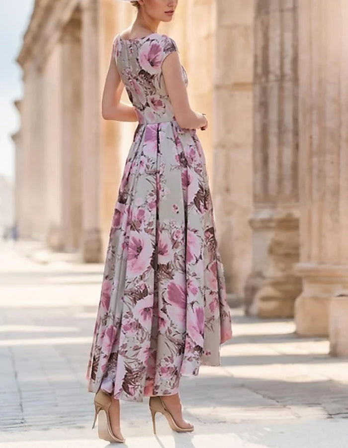Elegante taupekleurige satijnen hoge-lage jurk met cap sleeves en strik in de taille